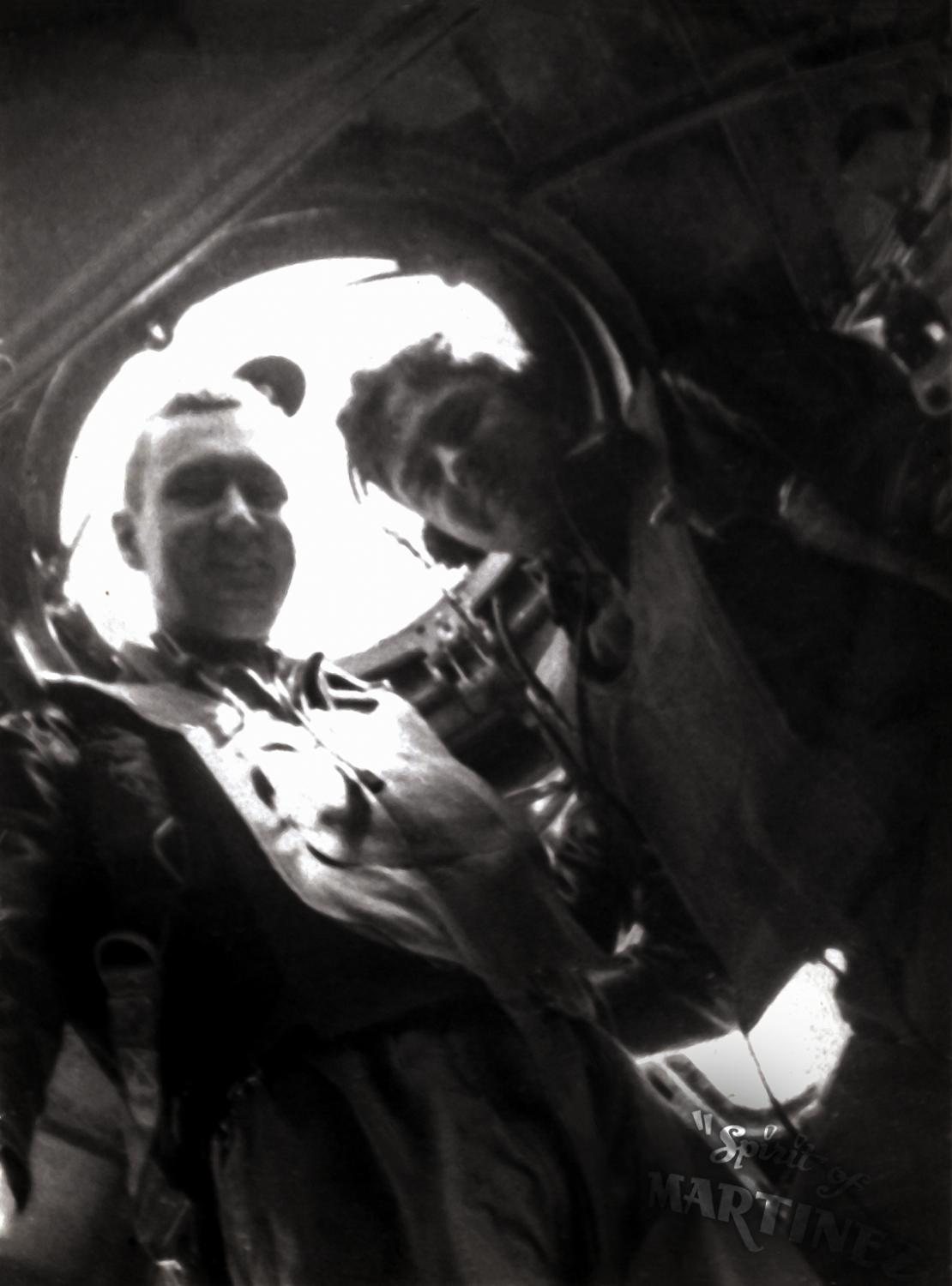 Two airmen at a B-17 window, backlit, one of them identified as Earle F. Bogacki