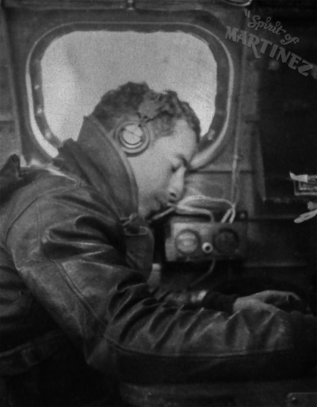 Radio operator Robert J. Brown at his set, oxygen mask on, a round window behind him