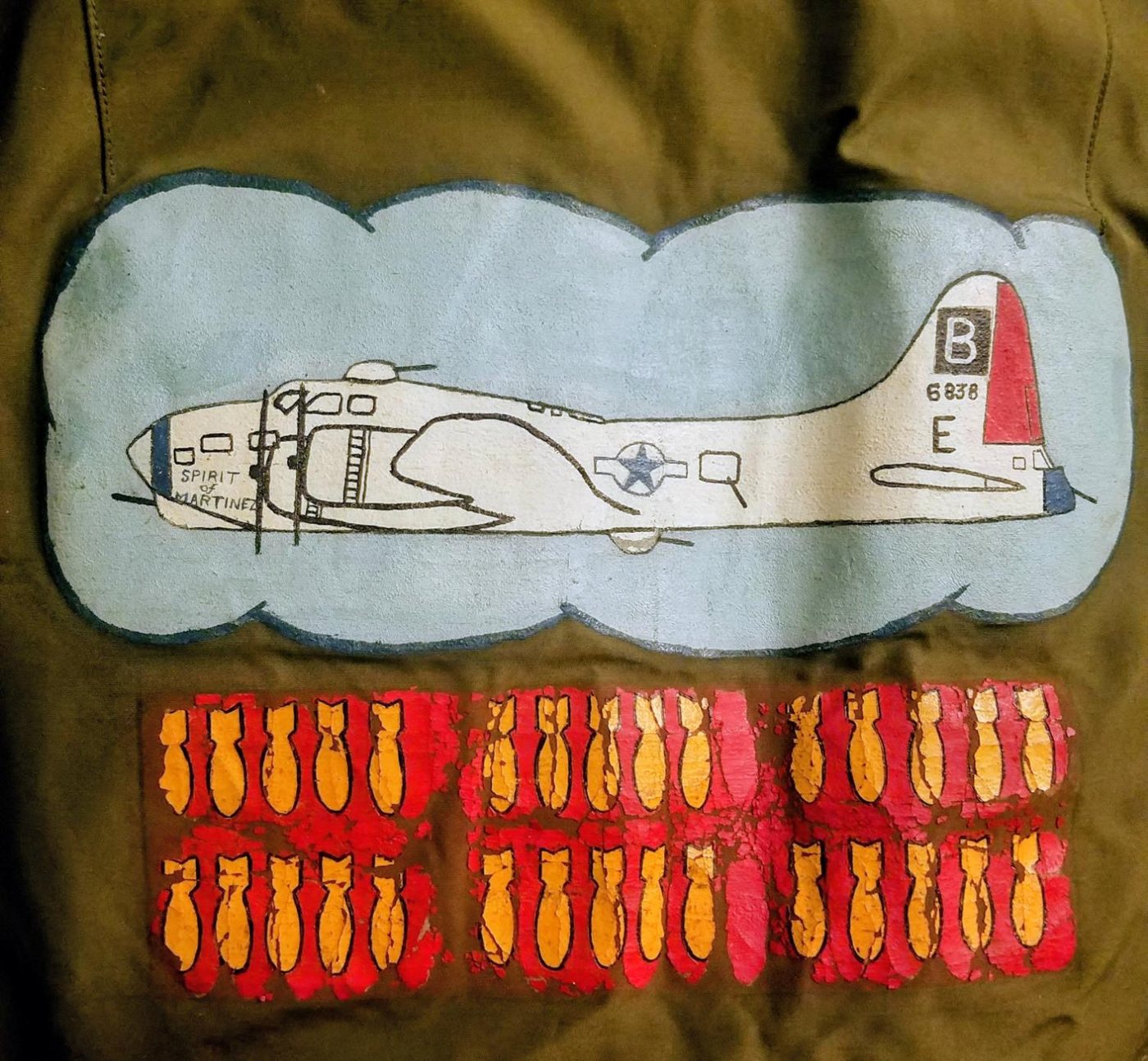 Painted B-17 Spirit of Martinez, serial 6838, call sign E, over two rows of yellow bomb symbols on an olive flight jacket