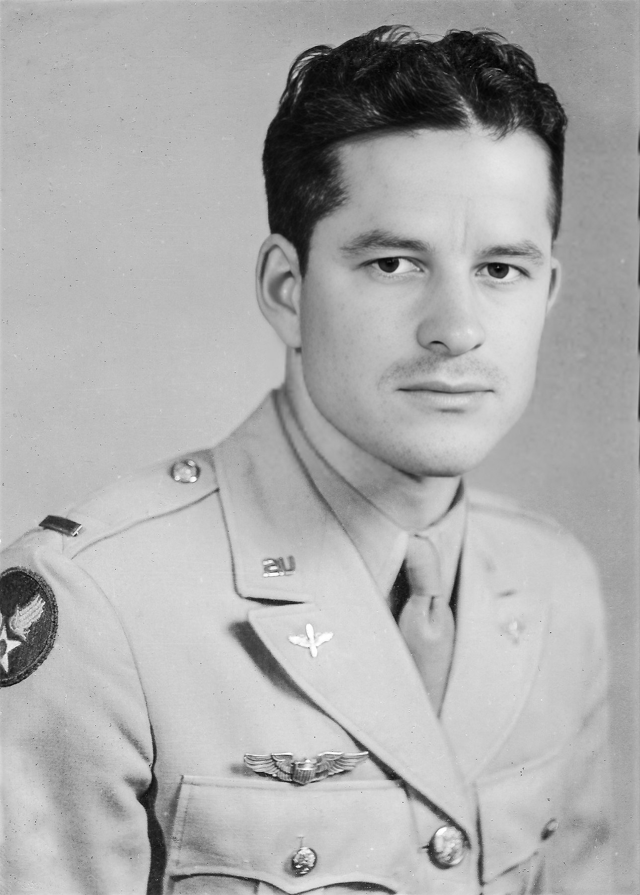 Studio portrait of Second Lieutenant Frank J. Calicura in Army Air Forces service dress, pilot wings and a winged-star patch on the shoulder