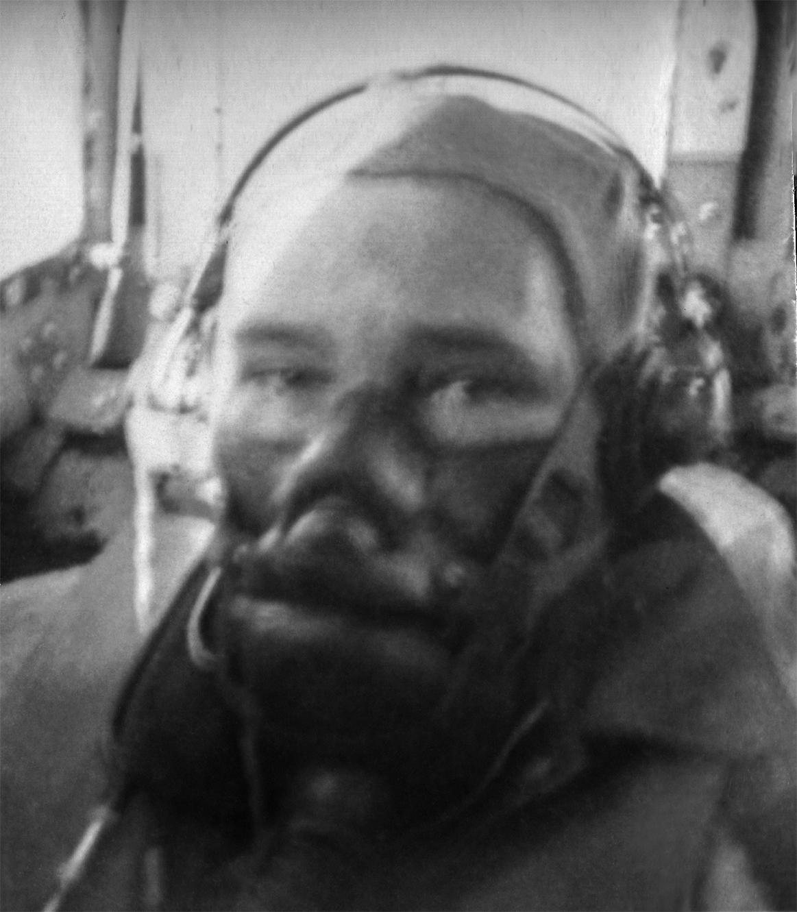 Tail gunner James A. Titus in leather helmet and oxygen mask, close to the camera