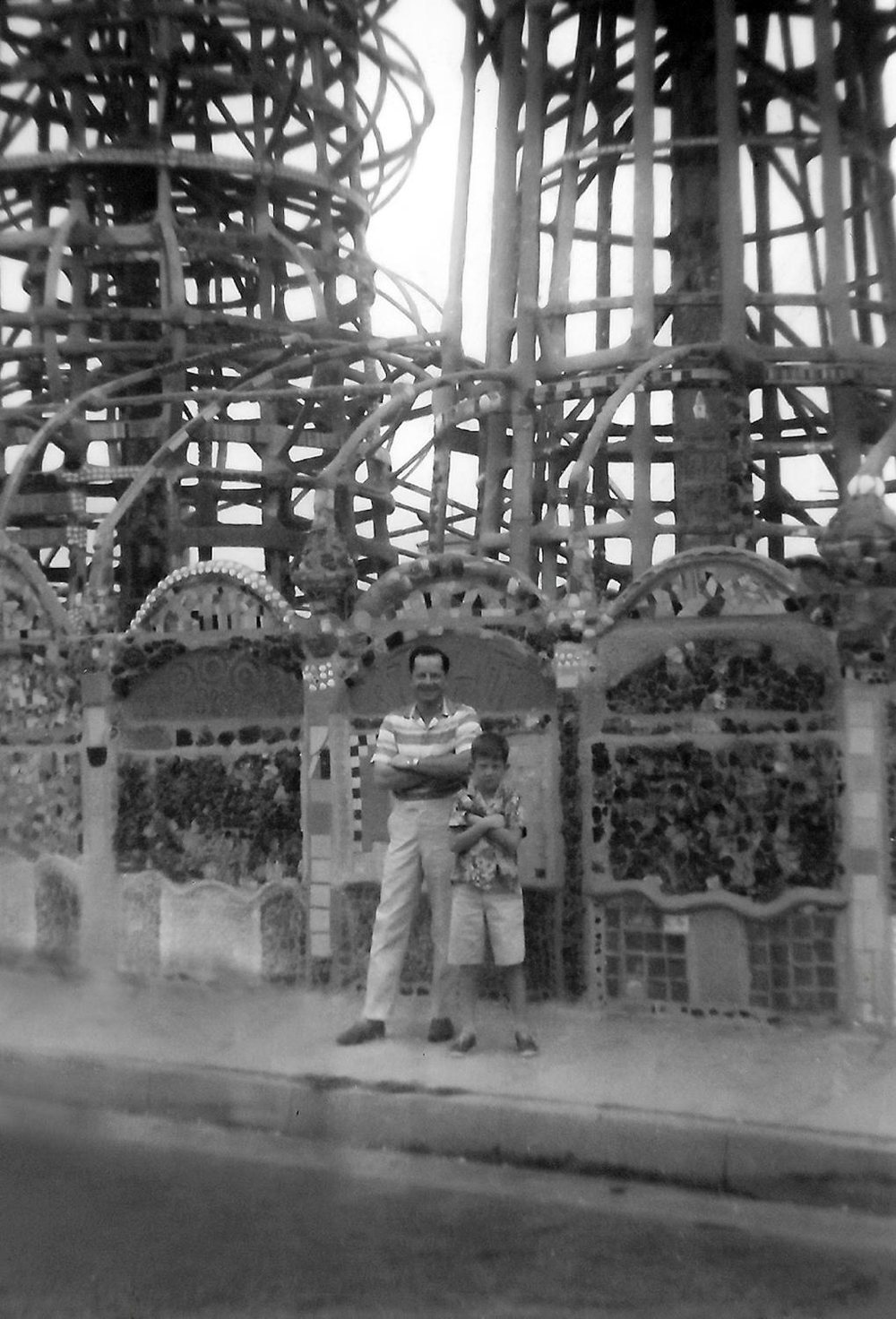 Frank Calicura and his young son Samuel standing with arms folded in front of the Watts Towers